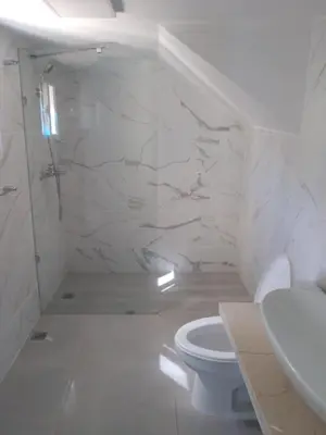 a white bathroom with a toilet and a sink at CoralK Apartments Sosúa in Sosúa