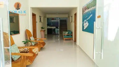 a corridor of a room with chairs and tables at CoralK Apartments Sosúa in Sosúa
