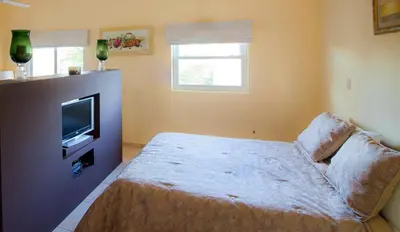 a bedroom with a bed and a tv and a couch at Ocean Dream High Ceiling Studio w/balcony in Cabarete