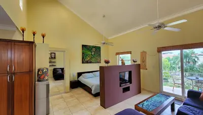 a bedroom with a bed and a tv in it at Ocean Dream High Ceiling Studio w/balcony in Cabarete