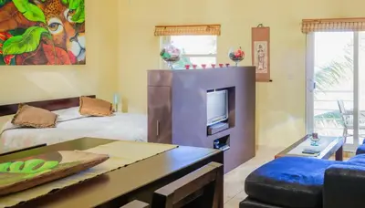 a living room with two beds and a tv at Ocean Dream High Ceiling Studio w/balcony in Cabarete
