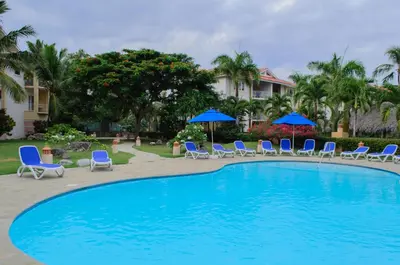 a large swimming pool with chairs and umbrellas at Ocean Dream Art Deco Studio w/balcony in Cabarete