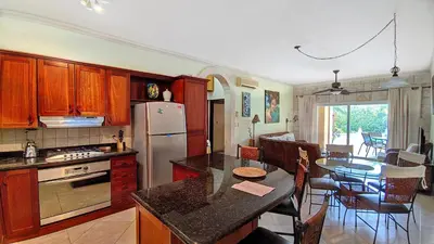 a kitchen with a refrigerator and a table with chairs at Ocean Dream 2bdr/2bth Ground floor in Cabarete