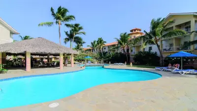 a swimming pool at a resort with palm trees at Ocean Dream Artist Loft 1st See Line in Cabarete
