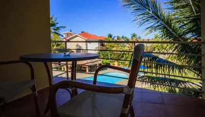 a table and chair on a balcony with a pool at Ocean Dream Studios Cabarete in Cabarete
