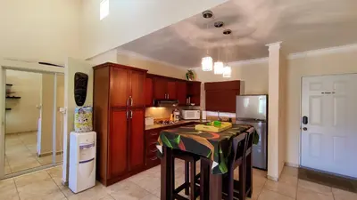 a kitchen with a table and a refrigerator at Ocean Dream Studios Cabarete in Cabarete