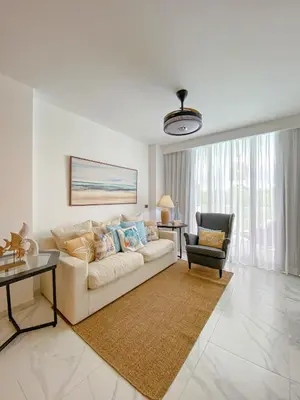 a white living room with a couch and a chair at Xeliter Cana Rock Punta Cana in Punta Cana