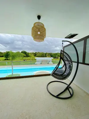 a swinging chair in front of a swimming pool at Xeliter Cana Rock Punta Cana in Punta Cana