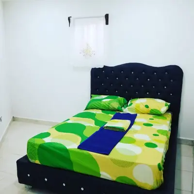a bed with a colorful comforter and pillows at Wilkan Hotel in Las Terrenas