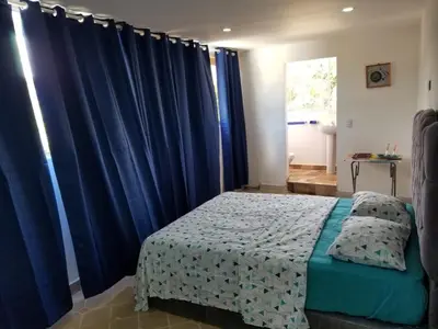 a bedroom with blue curtains and a bed in a room at Wilkan Hotel in Las Terrenas