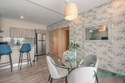 a dining room and kitchen with a glass table and chairs at Chic Fully Serviced Apartment at Regatta Living II - 705 in Los Prados