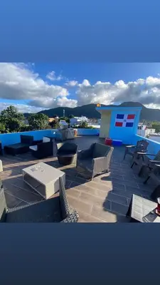 a patio with chairs and tables and a building at RESIDENCIAL DOÑA GLORIA in San Felipe de Puerto Plata