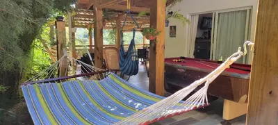 a hammock in a room with a pool table at Chalet los Pinos Constanza in Arroyo Frío
