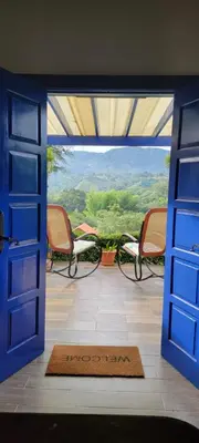 an open door to a porch with chairs and a view at Chalet los Pinos Constanza in Arroyo Frío