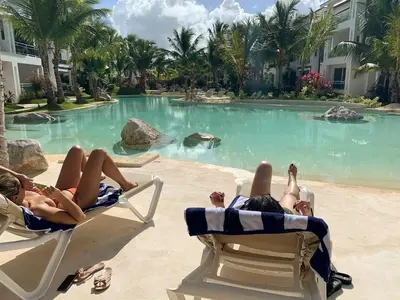 two people laying in chairs on the beach at a resort pool at Sunny garden in La Laguna