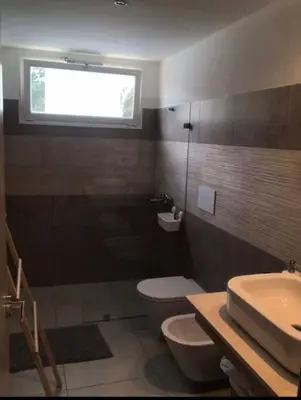 a bathroom with a toilet and a sink and a window at Sunny garden in La Laguna