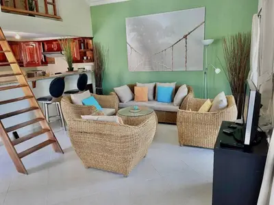 a living room with wicker chairs and a couch at The Cove Apartment Second Floor 5C in Santa Bárbara de Samaná