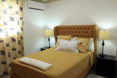 a bedroom with a large bed with two lamps at Fully Equipped New 2br Apt-dt2mins To The Beach in Sosúa