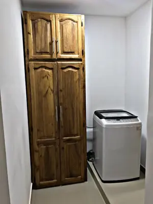 a wooden door in a room next to a toaster at Fully Equipped New 2br Apt-dt2mins To The Beach in Sosúa