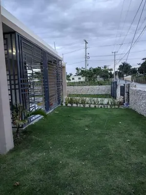 a yard next to a building with a grass yard at Cabrera Family Villa in Cabrera