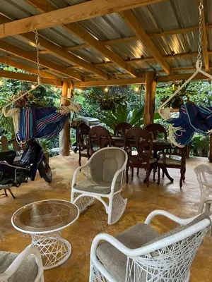 a patio with chairs and tables and a table at Villas Don Che, 2 villas in Jarabacoa