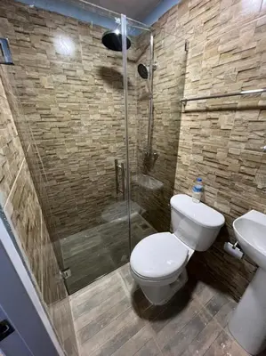 a bathroom with a toilet and a glass shower at Paulino in Santiago de los Caballeros