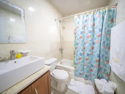 a bathroom with a sink and a toilet and a shower curtain at Fully Equipped 2br Apt-dt5mins To The Beach in Sosúa