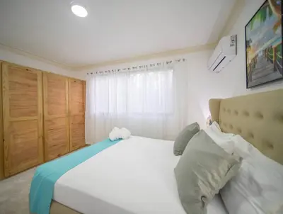 a bedroom with a large white bed and a window at Fully Equipped 2br Apt-dt5mins To The Beach in Sosúa