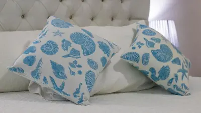 two blue and white pillows on a bed at Cozy and Central apartment 1br-1ba with Pool in Sosúa
