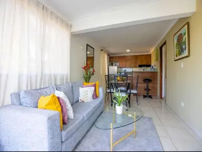 a living room with a couch and a table at Cozy and Central apartment 1br-1ba with Pool in Sosúa