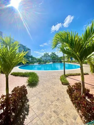 a swimming pool with palm trees in a resort at Escapade tropicale in Santiago de los Caballeros