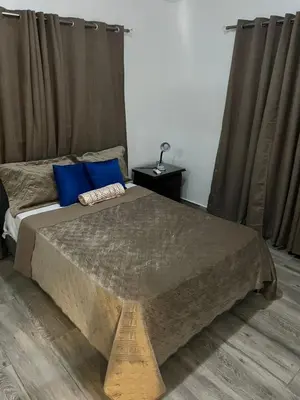 a bedroom with a large bed with blue pillows at Escapade tropicale in Santiago de los Caballeros