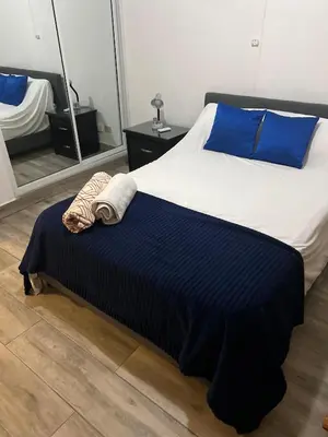 a bed with blue and white sheets and blue pillows at Escapade tropicale in Santiago de los Caballeros