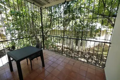 a balcony with a table and a large window at Room #27 at Waterfront Playa Alicia in Sosúa