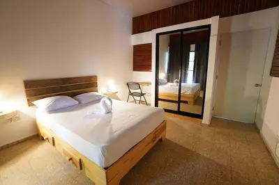 a bedroom with a large bed and a mirror at Room #26 at Waterfront Playa Alicia in Sosúa