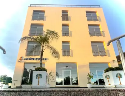 a yellow building with a palm tree in front of it at LA VlTA E' BELLA in Los Mameyes