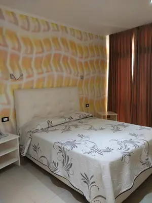 a bedroom with a white bed with a wall at LA VlTA E' BELLA in Los Mameyes