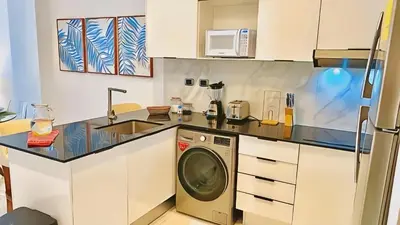 a kitchen with a washing machine and a sink at Hermoso Apartamento Cana Rock Star Acceso Directo a la Piscina C-105, C-106, B-102 y B-104 in Punta Cana