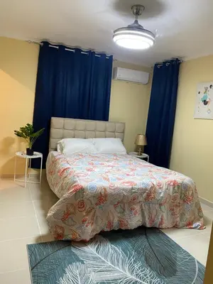 a bedroom with a large bed with blue curtains at Casa Apartamento Valentina in Santo Domingo