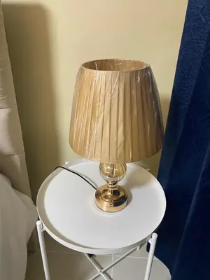 a lamp on a white table next to a bed at Casa Apartamento Valentina in Santo Domingo