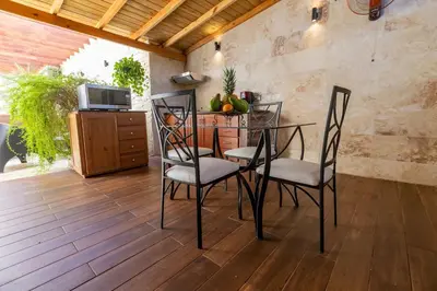 a dining room with a table and chairs on a wooden floor at Central Area Bedroom With Common Kitchen, living room in Sosúa