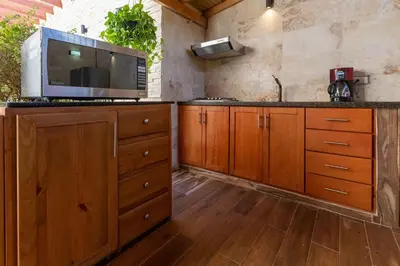a kitchen with wooden cabinets and a microwave at Central 1bd and Bth with common Picuzzi in Sosúa