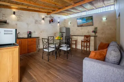 a kitchen and a living room with a table and chairs at Central 1bd and Bth with common Picuzzi in Sosúa