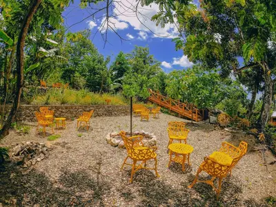 a group of chairs and tables in a yard at EL GALLO ECOLODGE in San Felipe de Puerto Plata