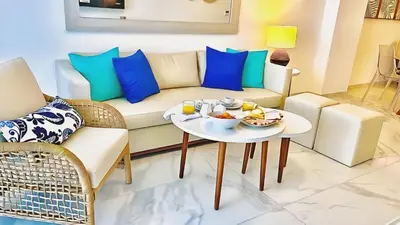 a living room with a couch and a table with food on it at Cana Rock Star, Vista al campo de golf y Piscina C-303, B-400, B-506 y B-502 - Desayuno in Punta Cana
