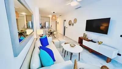 a living room with a couch and a tv at Cana Rock Star, Vista al campo de golf y Piscina C-303, B-400, B-506 y B-502 - Desayuno in Punta Cana