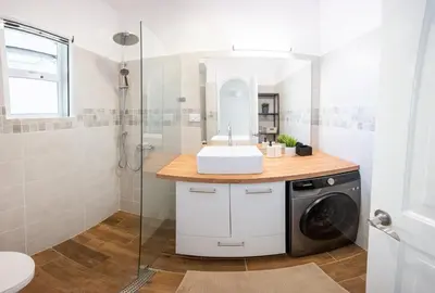 a bathroom with a sink and a washing machine at Family Dominicus Apartment - Bayahibe in Bayahibe