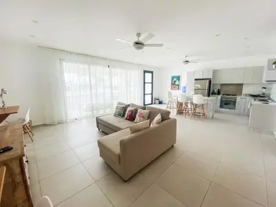 a living room with a couch and a kitchen at Stella Aparthotel, Las Terrenas in Las Terrenas