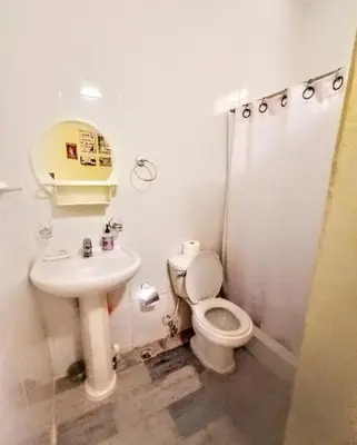 a bathroom with a toilet and a sink at Paraiso Hortensia Ecolodge in Santiago de los Caballeros