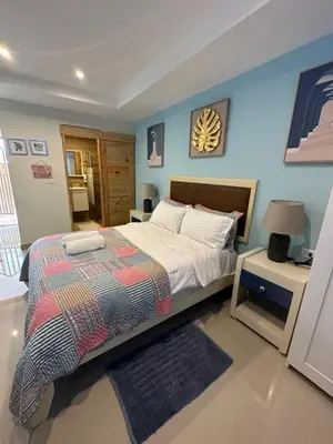 a bedroom with a bed and a blue wall at Noe Hotel , One Bed Room Close to The beach Room #1 in Punta Cana